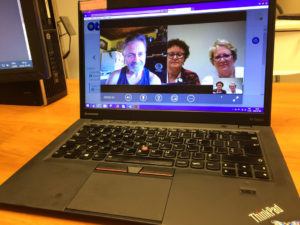 Trois personnes en conversation virtuelle sur un ordinateur portable