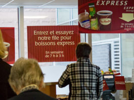File de gens devant le comptoir de service du Tim Hortons.