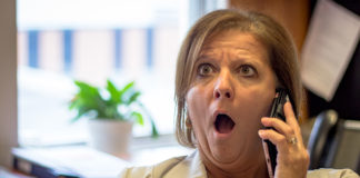 Méfiez-vous des fraudeurs Femme surprise en parlant au téléphone.