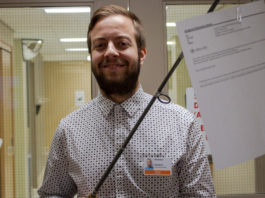 Un technicien en informatique tient une canne à pêche au bout de laquelle on peut voir un courriel indésirable