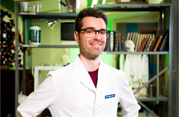 Homme en sarrau blanc souriant mains sur les hanches