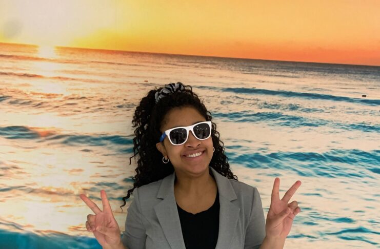 Femme noire avec lunettes de soleil devant une murale