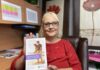 Femme blonde avec chandail rouge qui tient un pamphlet sur la retraite