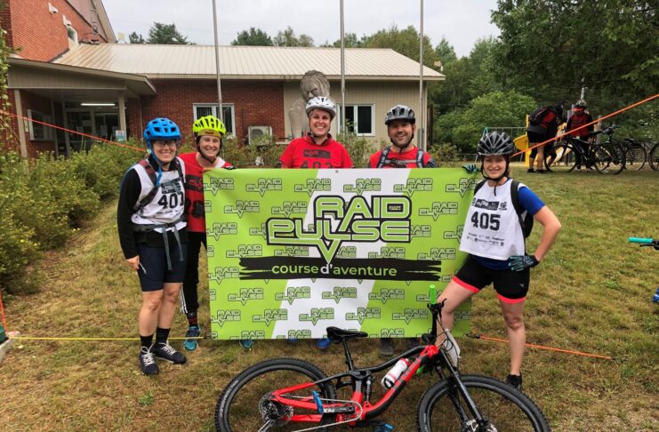 5 adultes devant une bannière en équipement sportif