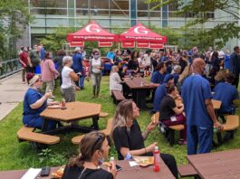 Groupe d'employés de Montfort en train de manger dans la cour intérieure de l'hôpital