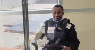 Agent de sécurité assis à un bureau, souriant