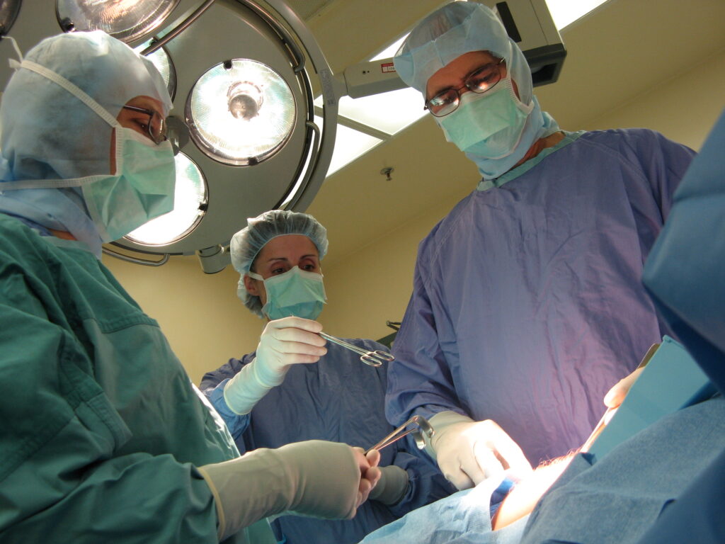 Deux médecins et une infirmière en train de pratique une chirurgie