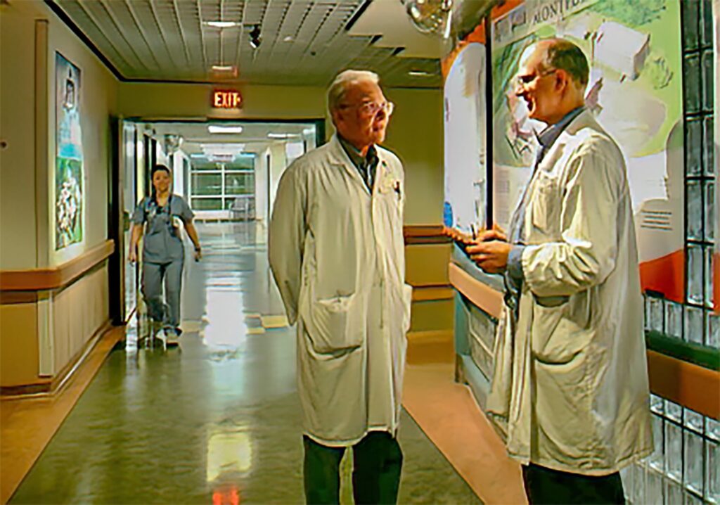 Deux médecins en sarrau blancs parlent dans le corridor de l'hôpital