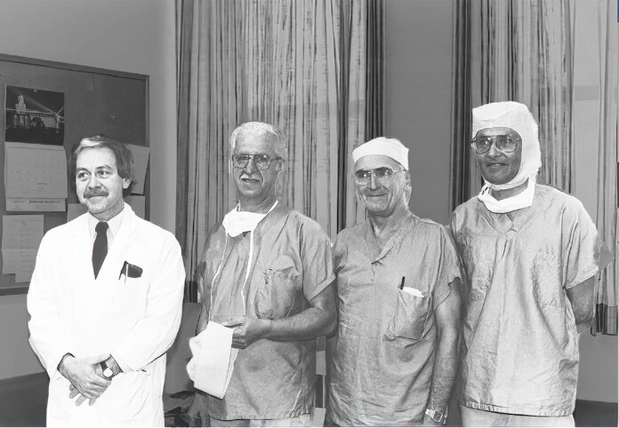 Drs Gilles Boudreau, Laureat Tremblay, Guy Lefebvre, Ramesh Chauhan Photo d'archive en noir et blanc, quatre chirurgiens vêtus pour entrer à la salle d'opération