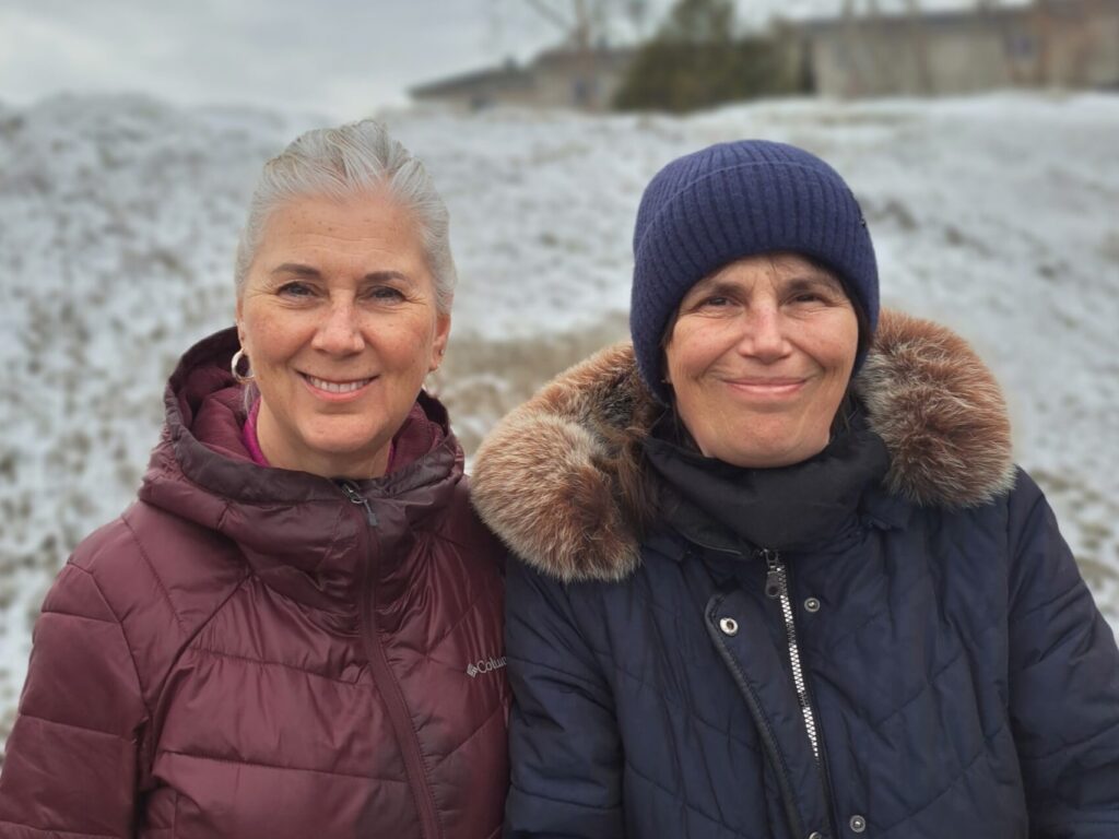 Les deux soeurs Suzanne et Marie-France Bélair. Elles sont à l'extérieur, vêtues de manteau d'hiver, et les deux sont souriantes.