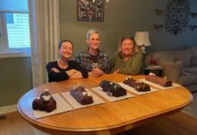 Trois femmes devant cinq bûches de Noël sur une table de cuisine