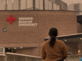 Femme en chandail brun devant une urgence avec de la neige
