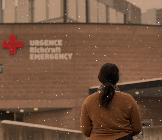 Femme en chandail brun devant une urgence avec de la neige