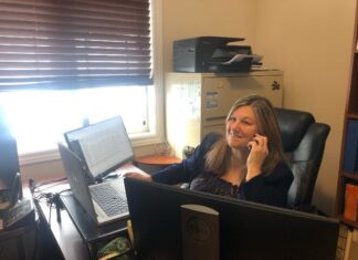 Femme au téléphone dans un bureau devant un ordinateur