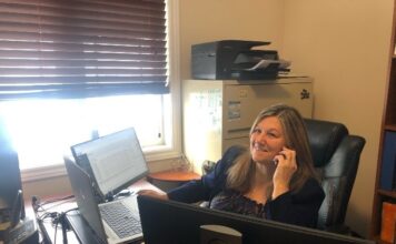 Femme au téléphone dans un bureau devant un ordinateur