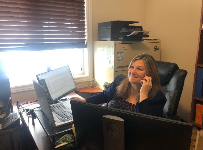 Femme au téléphone dans un bureau devant un ordinateur