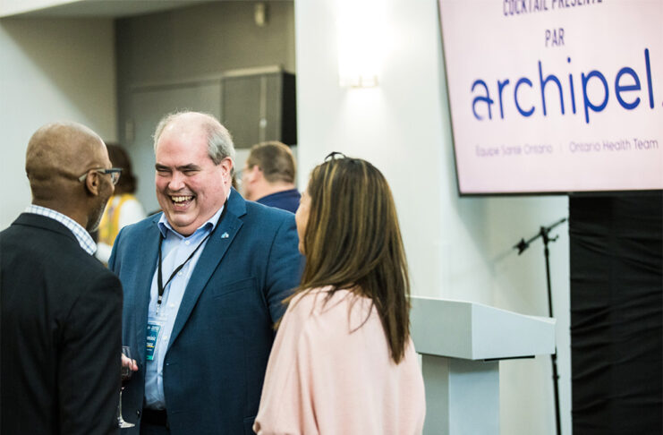 Trois individus discutant dans un rassemblement.