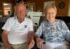 un homme et une femme assis se tenant la main